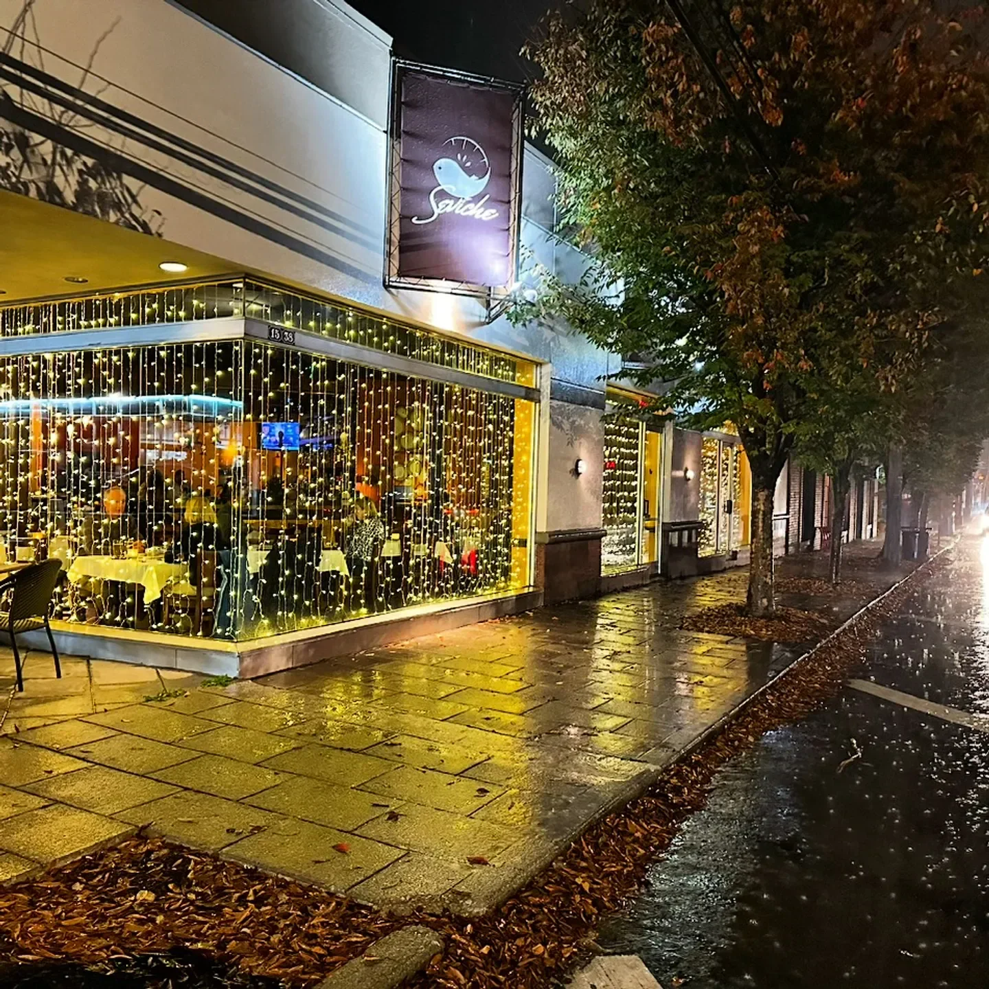 Exterior of Seviche restaurant in Louisville, lit up at night with string lights.
