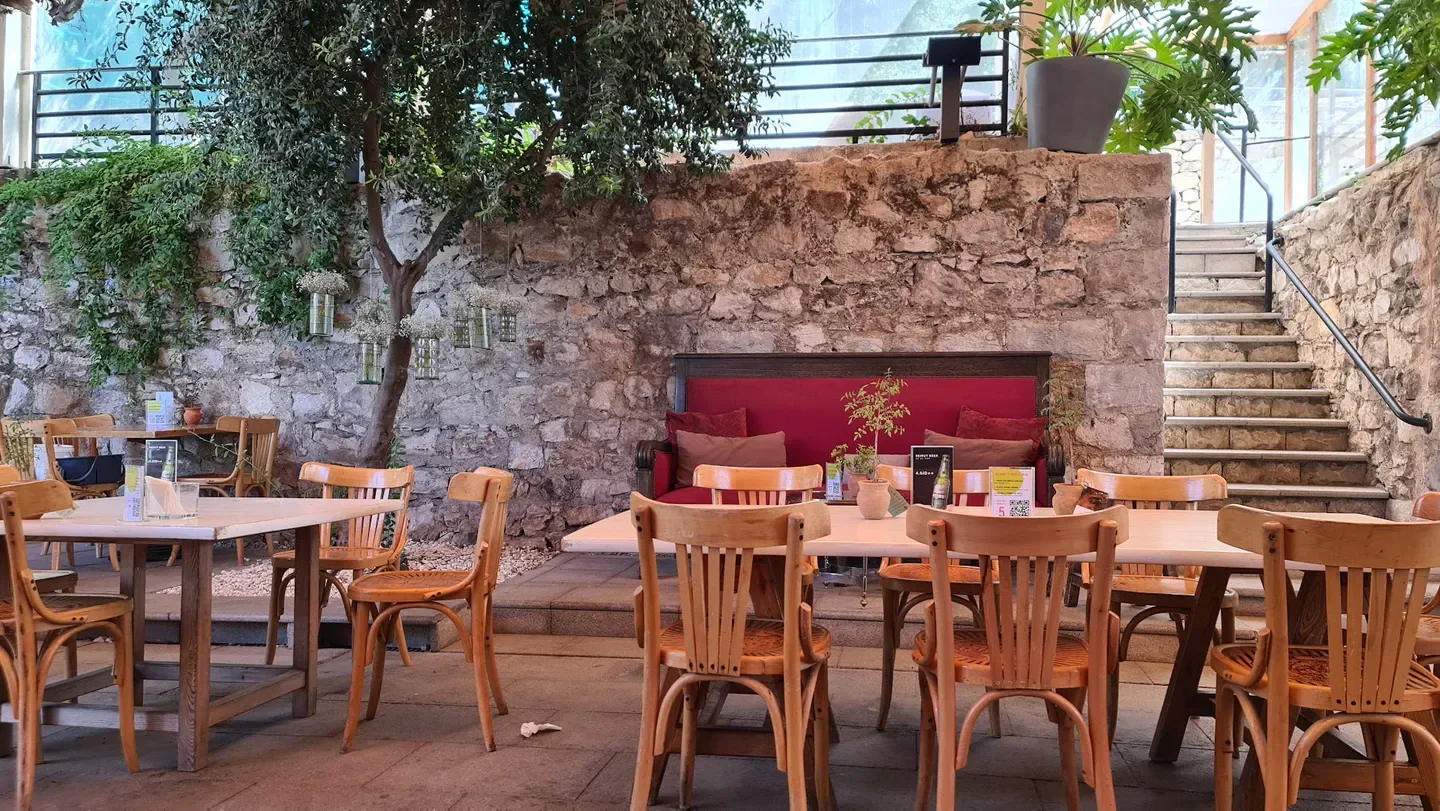 Cozy outdoor seating at Shams El Balad restaurant in Amman with rustic stone walls.