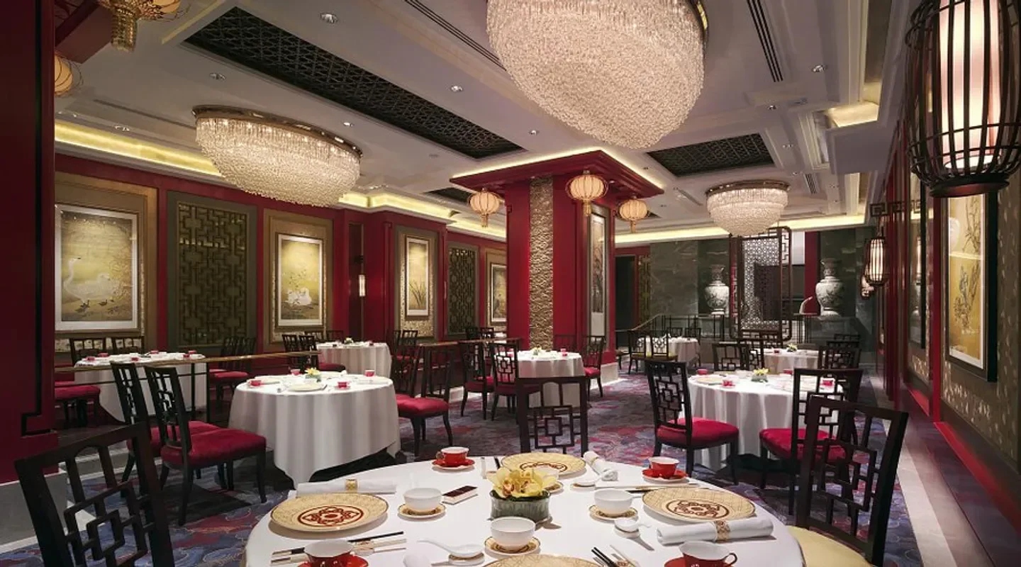 Elegant dining room at Shang Palace - Hong Kong with chandeliers and red accents.