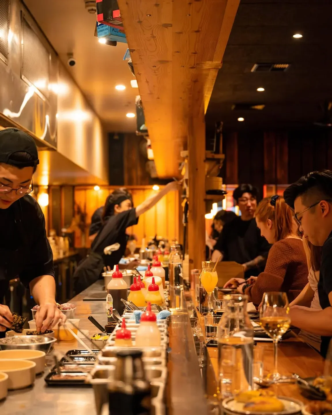 Busy bar scene at Shobosho restaurant in Adelaide, with chefs and customers enjoying food.