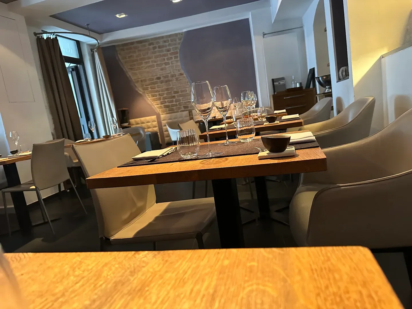 Showroom restaurant in Munich, featuring stylish tables with wine glasses and elegant seating.