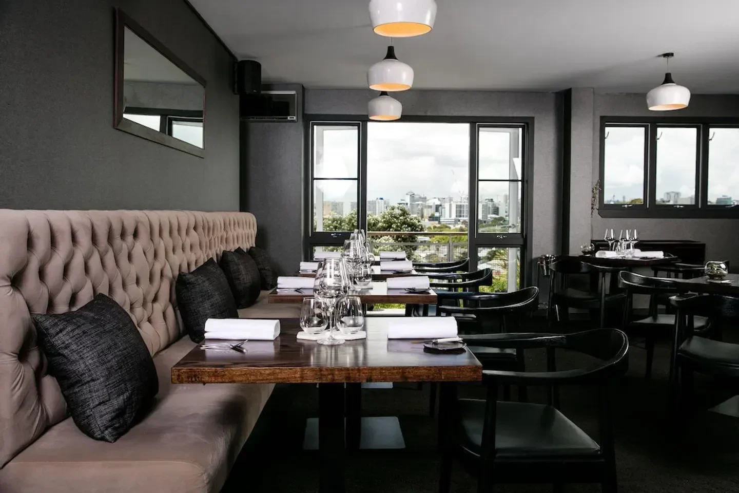 Interior of Sidart restaurant in Auckland, with a view of the city skyline through the window.