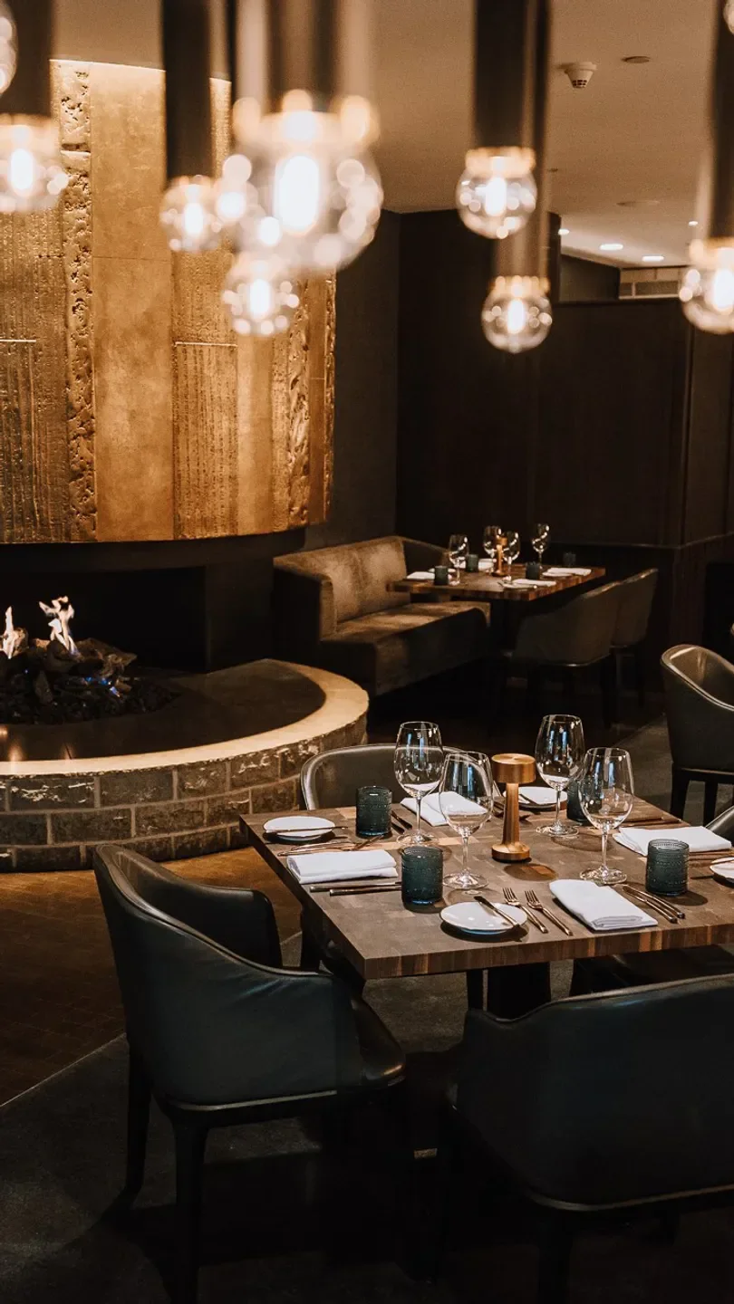 Elegant dining at SIDECUT Steakhouse in Whistler with fireplace and ambient lighting