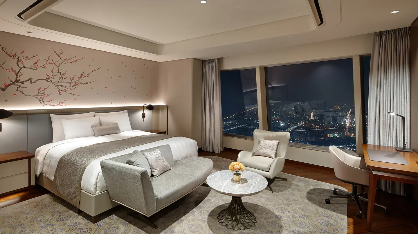 Luxury hotel room at Signiel Seoul with stunning city views of Seoul at night.