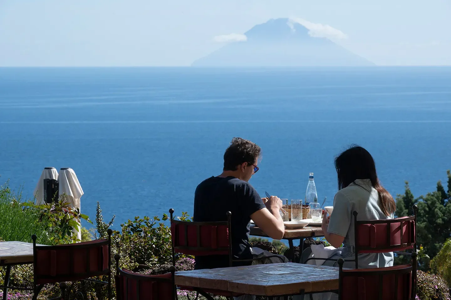 Dining at Signum restaurant in Sicily with sea views and a distant island