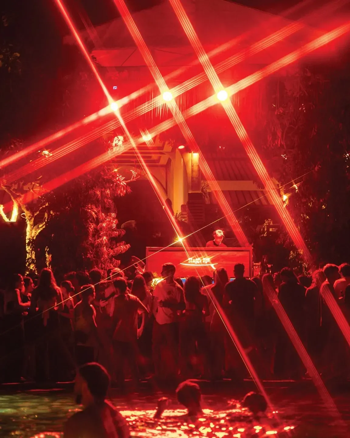 Party at Single Fin beach club in Bali with DJ and red laser lights.