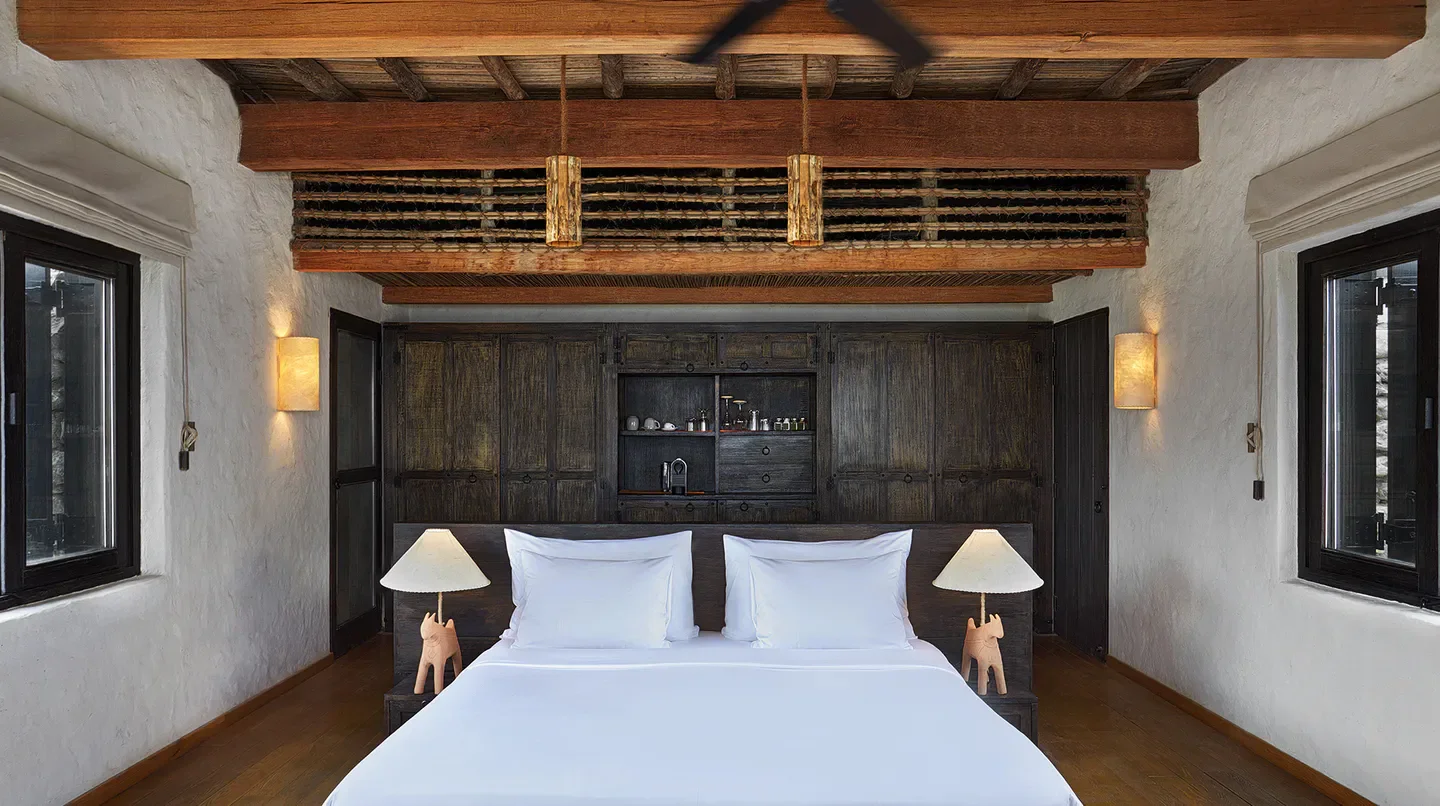 Cozy bedroom interior at Six Senses Zighy Bay Resort in Muscat, featuring wooden accents.