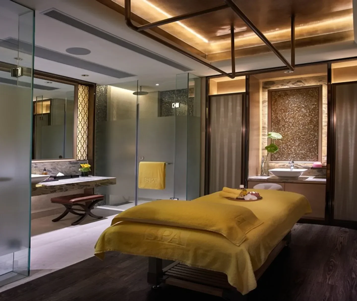 Relaxing spa treatment room at Sky Club Spa in Hong Kong, featuring massage bed and shower.