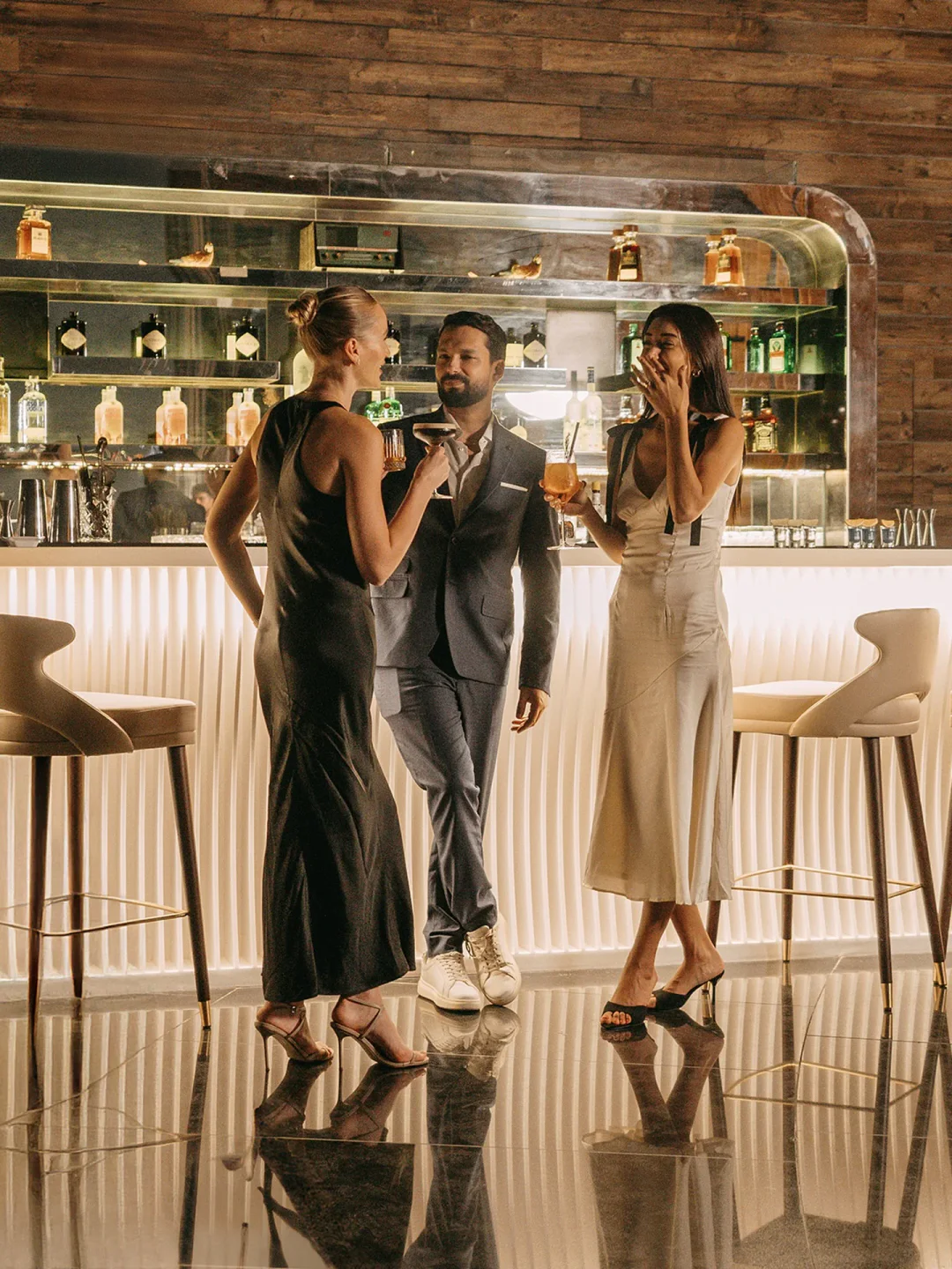 Stylish couples enjoying cocktails at the chic Sky View rooftop bar in Doha with a modern bar background.