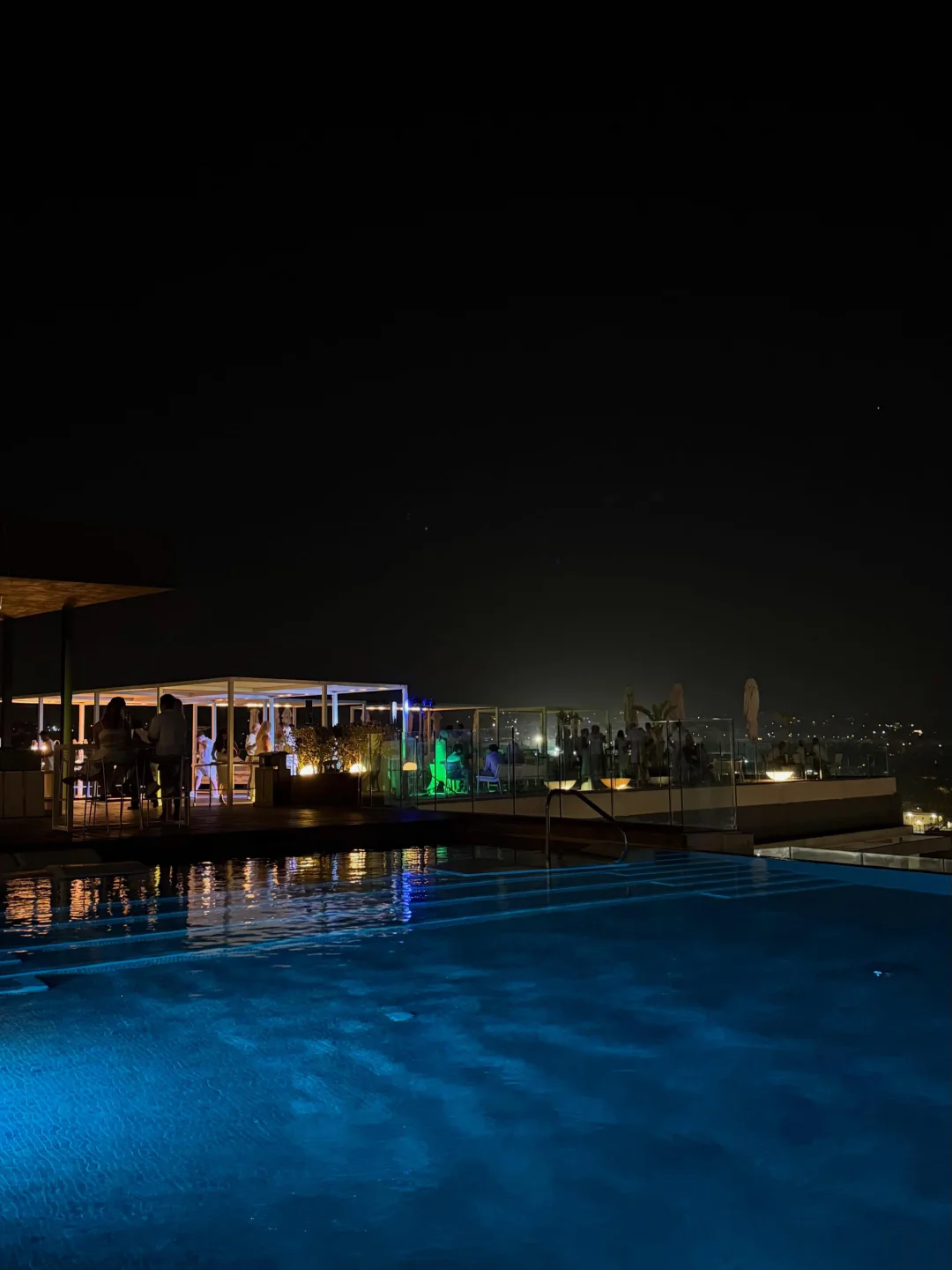 SKYBEACH Malta rooftop ambiance at night with an illuminated pool and vibrant lounge area
