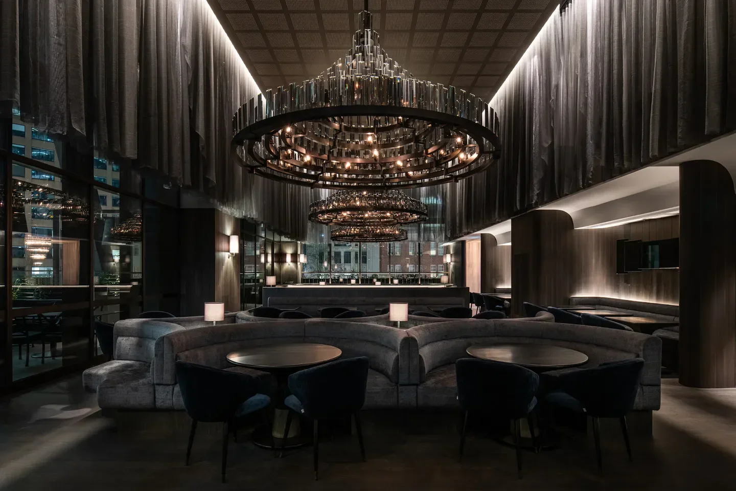Elegant dining interior at Society restaurant in Melbourne with ornate chandeliers and booths.