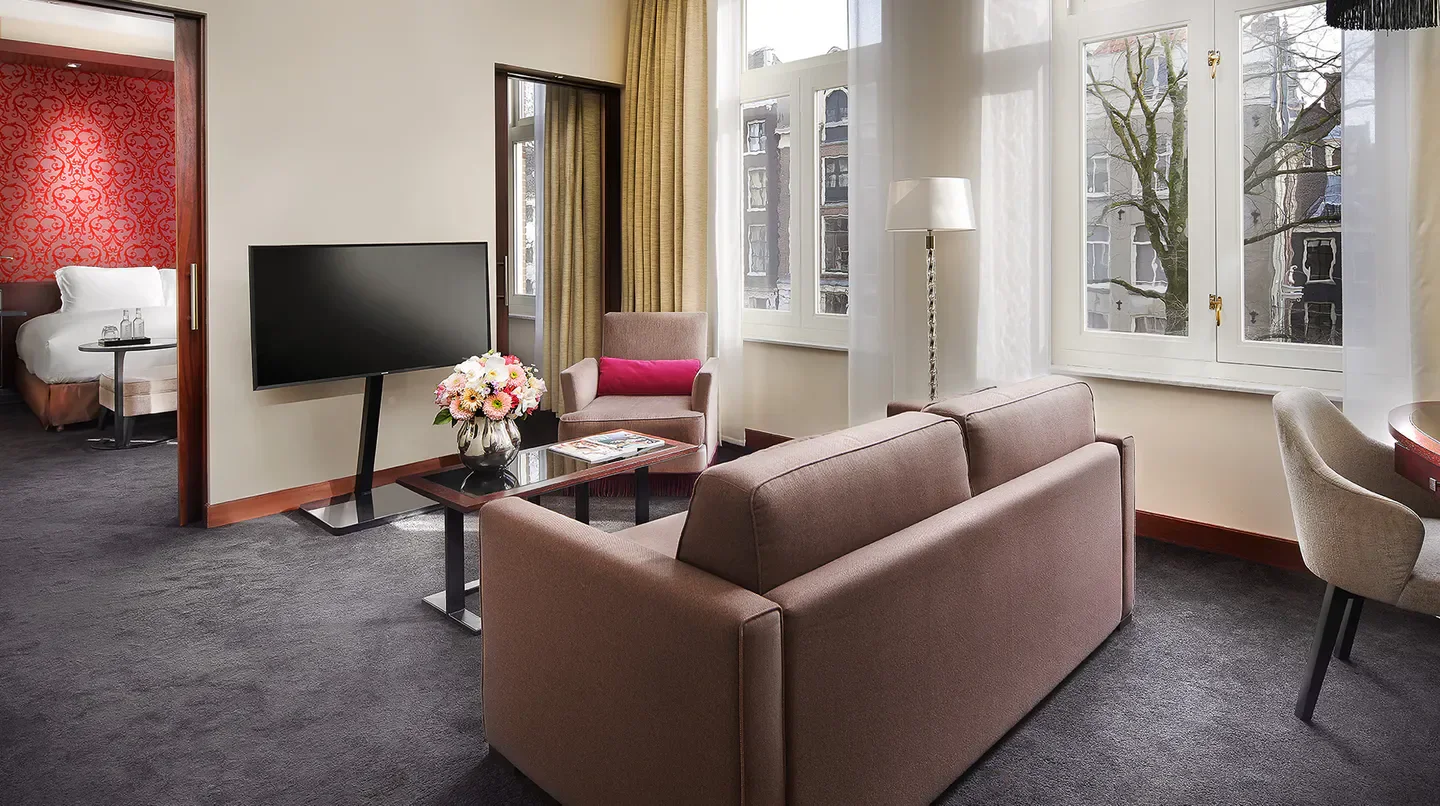 Elegant suite interior at Sofitel Legend The Grand Amsterdam, Amsterdam, with city views.