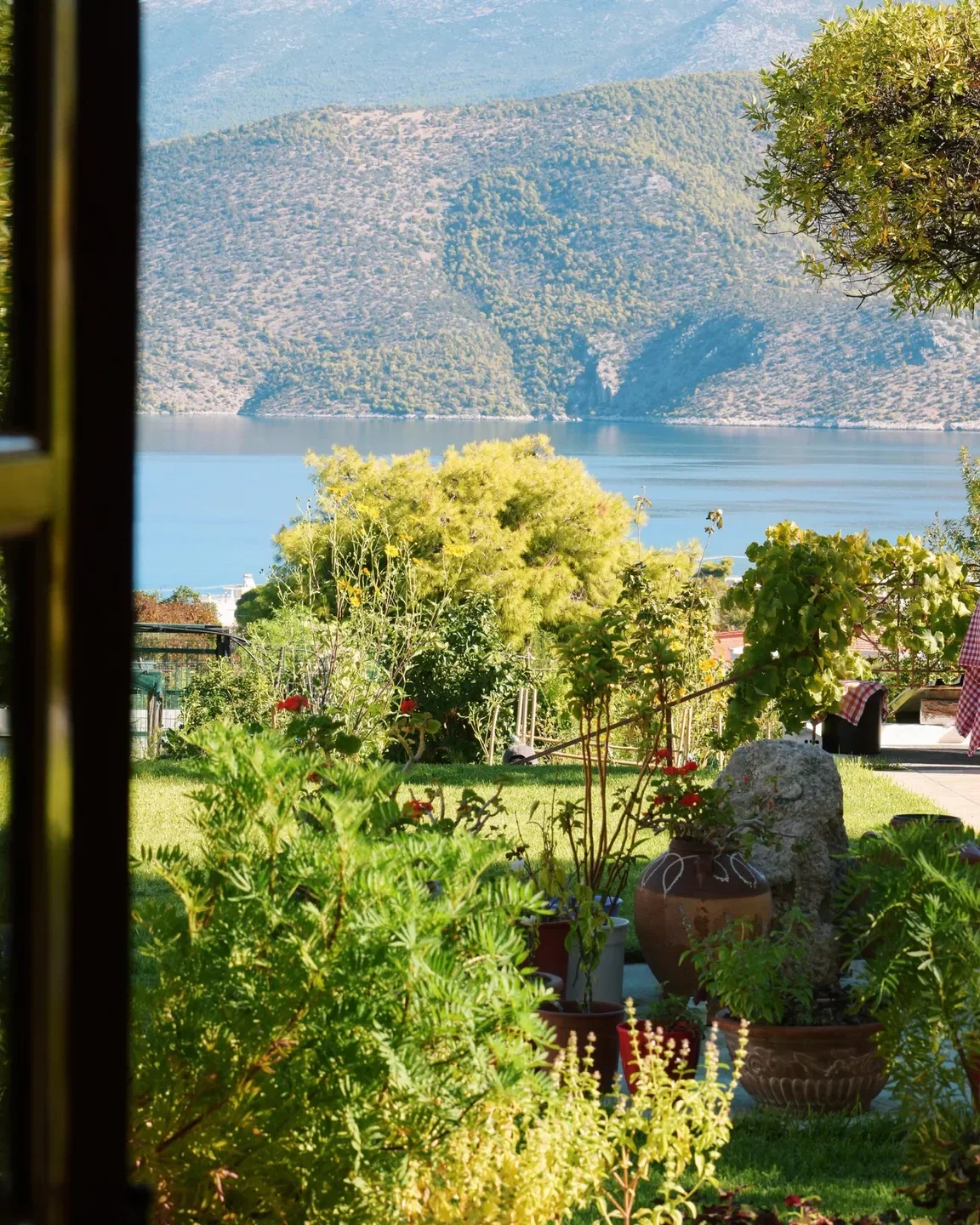 Scenic view at Soil restaurant in Athens, Greece, with lush garden and water view.