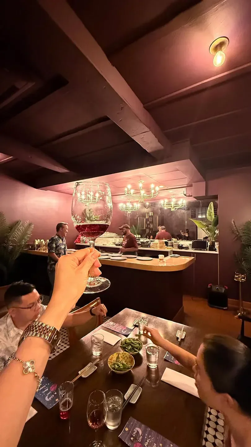 Cheers at Sooper Secret Izakaya in Honolulu, with a glass of red wine.