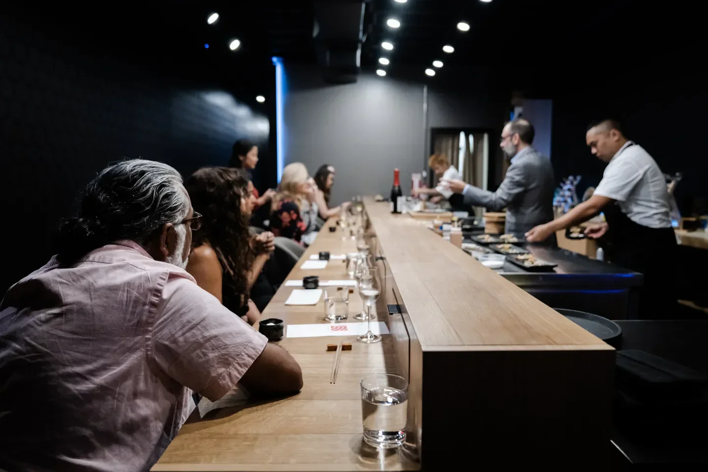 Dining at Soseki Orlando: Guests at the sushi counter while chefs prepare the food.