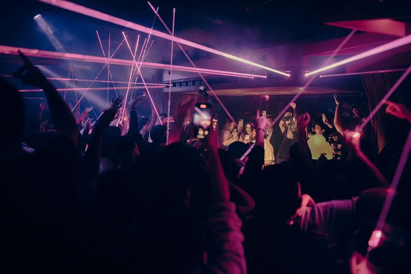 Energetic crowd at Soubois nightclub in Montreal, illuminated by laser beams and lights.