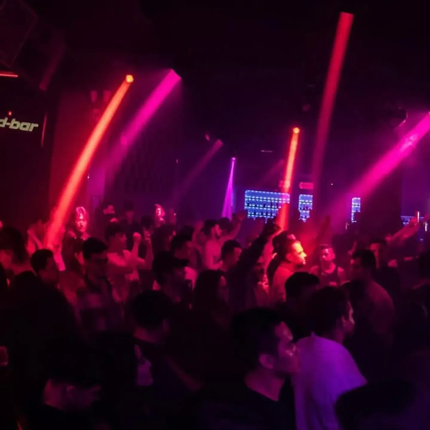 Energetic crowd at Sound Bar Chicago nightclub, illuminated by vibrant pink lights.