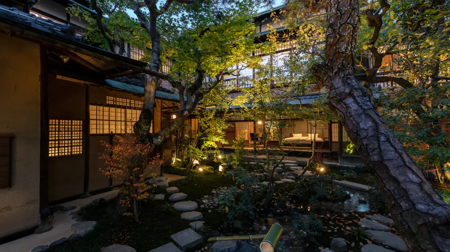 Tranquil garden at SOWAKA in Kyoto, with traditional Japanese architecture and lush greenery.