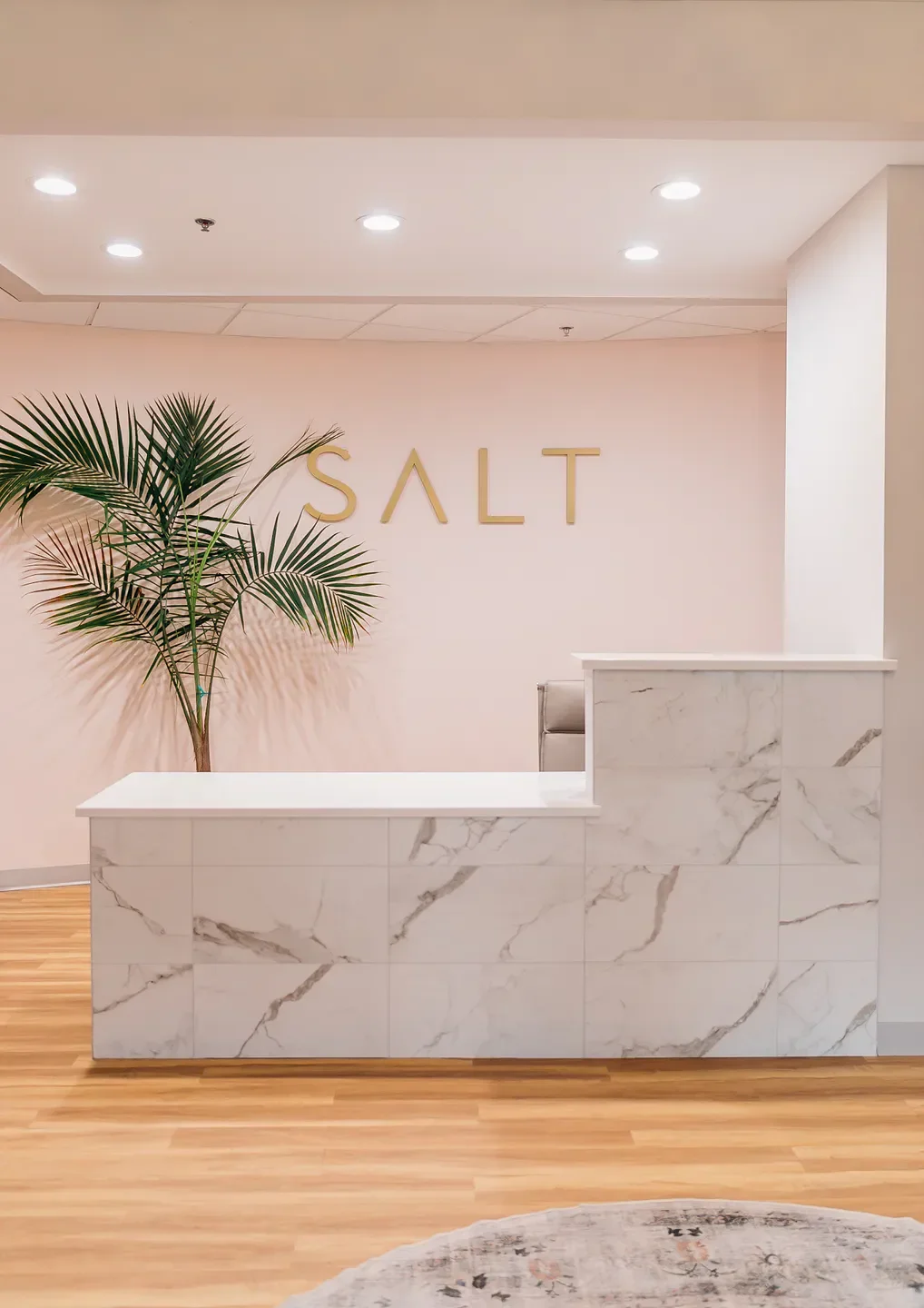 Reception area at Spa du Soleil in Virginia Beach with a modern marble counter and decor.
