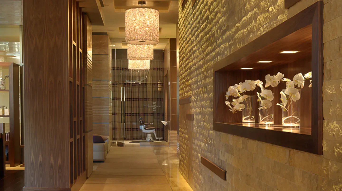Interior hallway at Spa Mio in Las Vegas, featuring floral displays and elegant lighting.