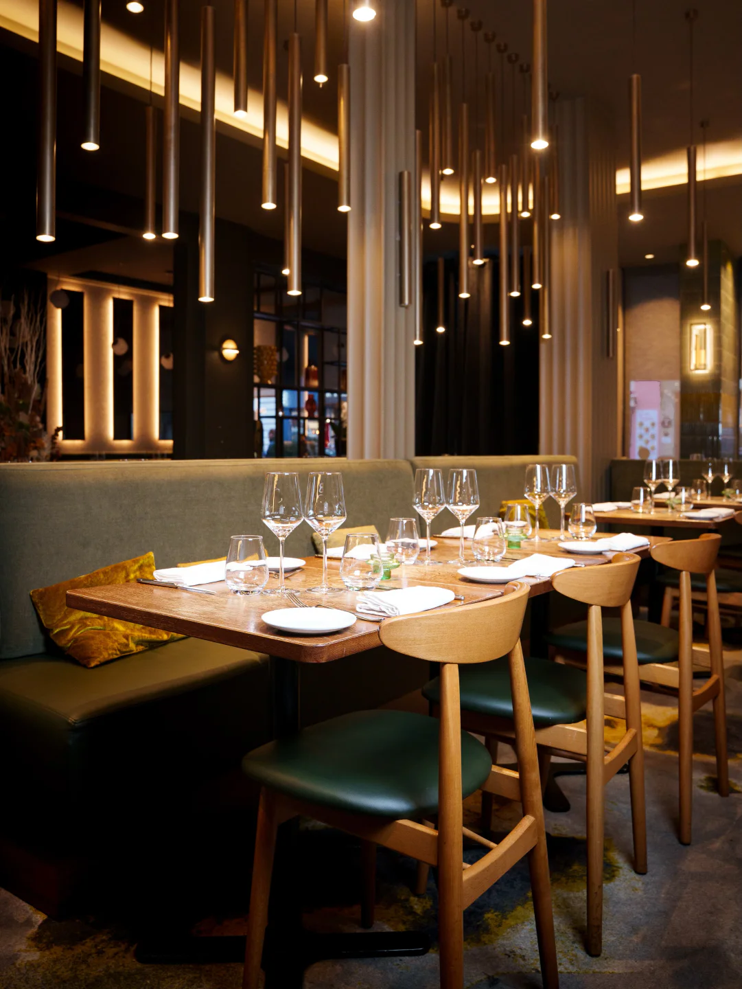 Modern dining setup at Sphère restaurant in the city, featuring wooden tables, elegant glassware, and ambient lighting.