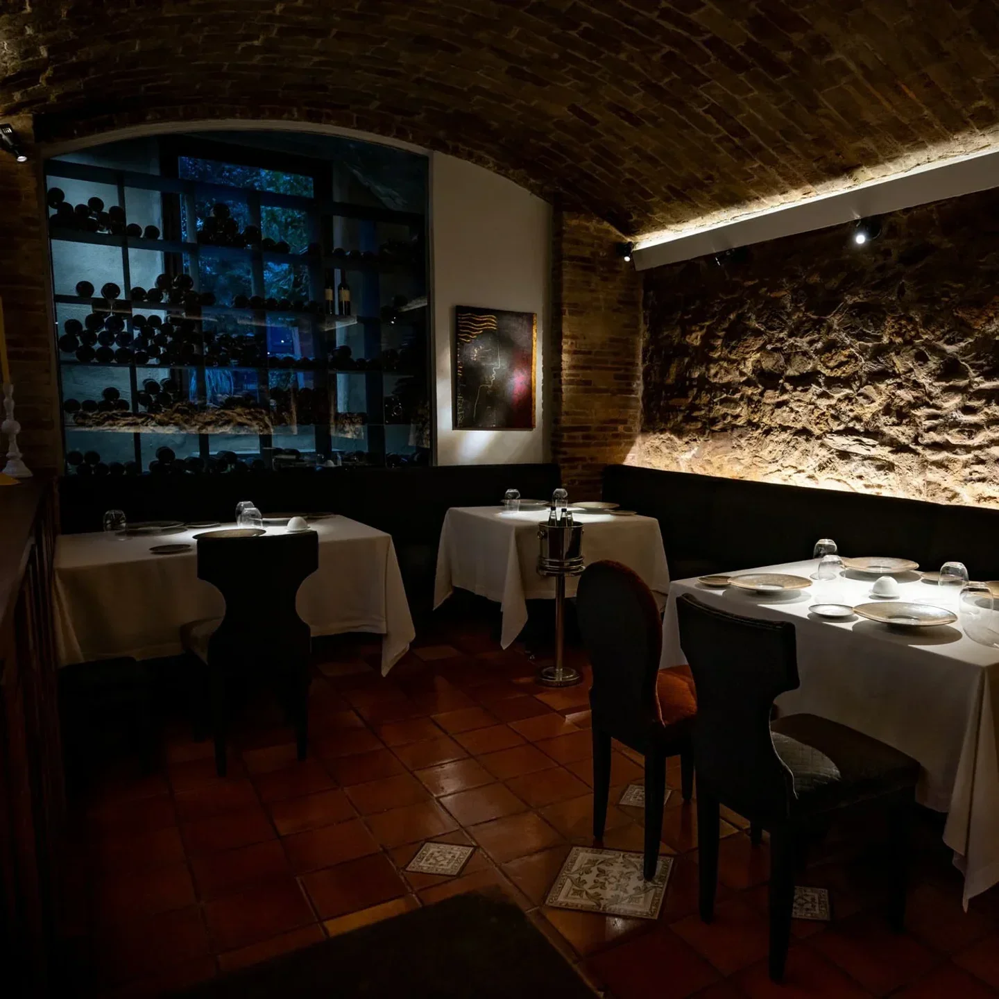 Cozy dining room at Spondi restaurant in Athens with brick walls and wine display