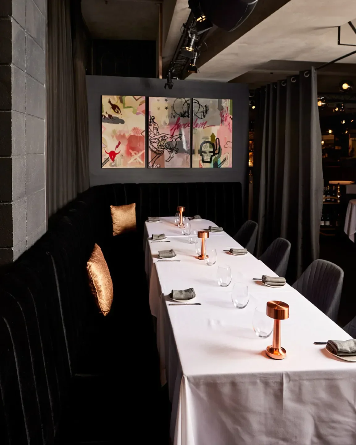 Interior of Steer Dining Room in Melbourne: elegant table setting with art on the wall.