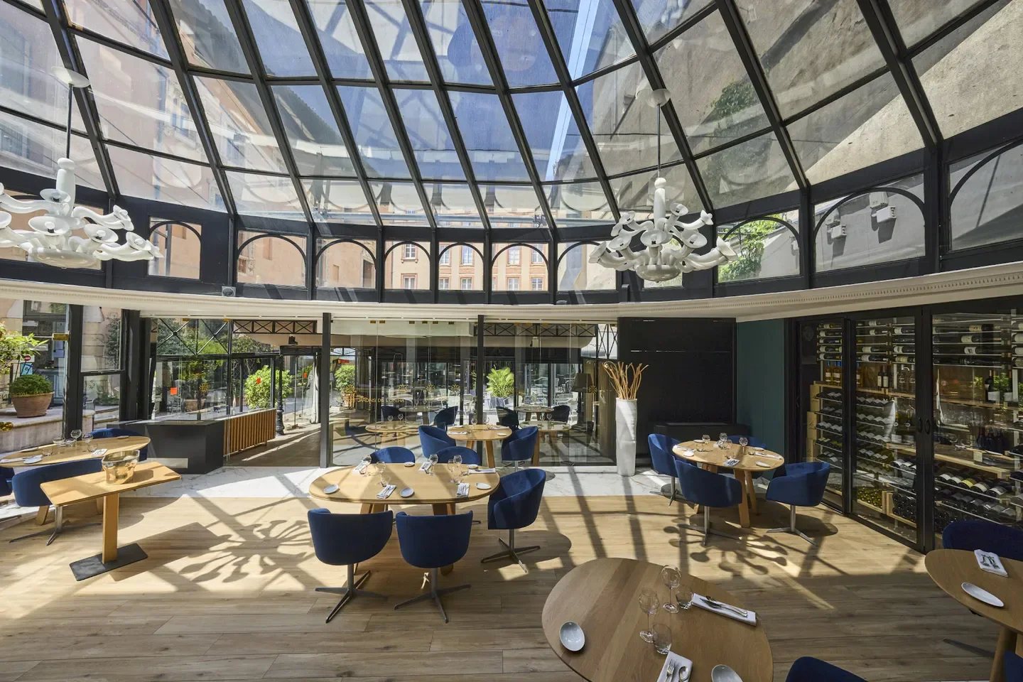 Elegant dining room at Stéphane Tournié - Les Jardins de l'Opéra in Toulouse, with glass ceiling.