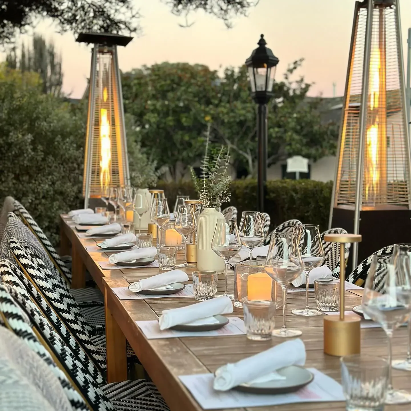 Outdoor dining at Stokes Adobe in Carmel, with heaters and a beautifully set table.