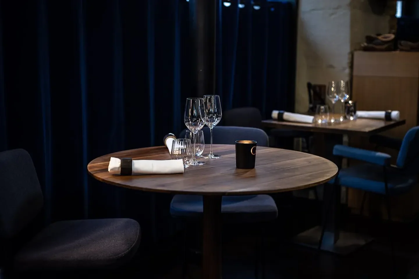 Elegant dining table setting at Substance restaurant in Paris, featuring glasses and candle.