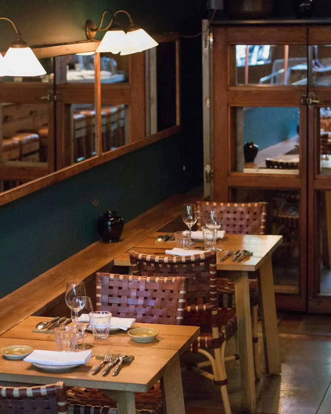 Cozy interior of Succulent restaurant in Barcelona, with wooden tables and woven chairs.