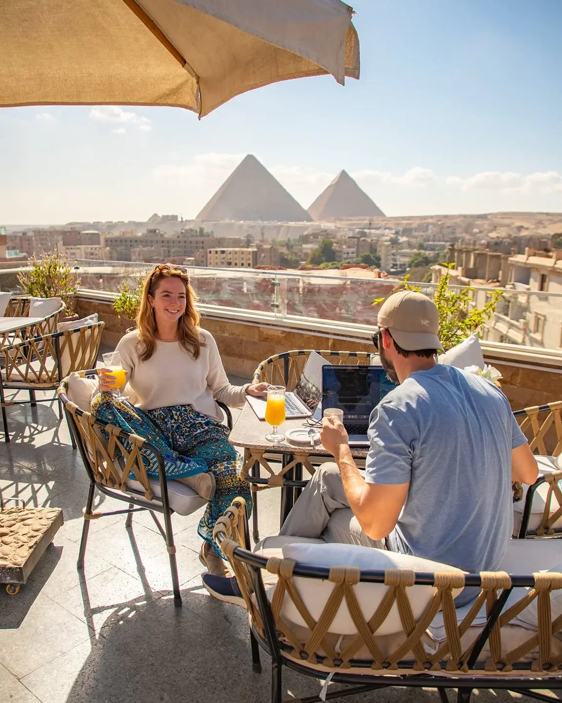 Couple enjoying drinks at Sufra Amman restaurant with iconic pyramid views
