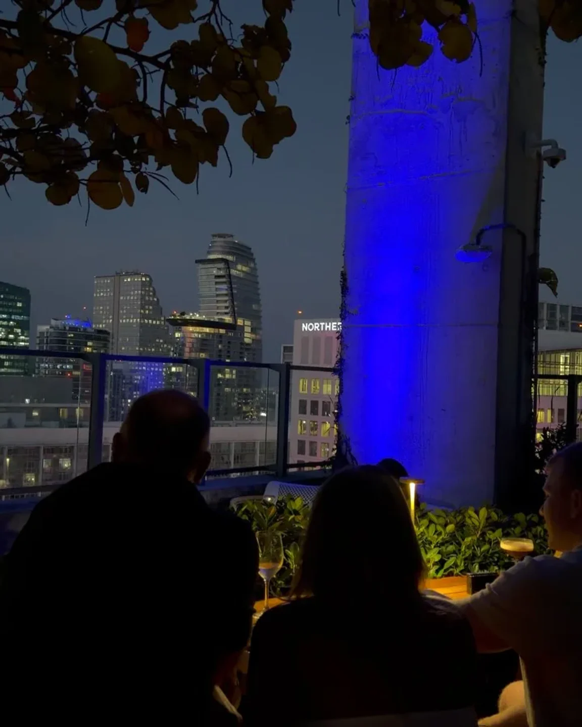 View of Miami skyline from Sugar rooftop bar with people enjoying drinks at dusk