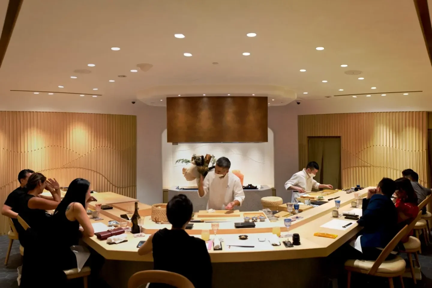 Chef at work in Sushi Masaaki, Singapore, preparing food for customers at the counter.