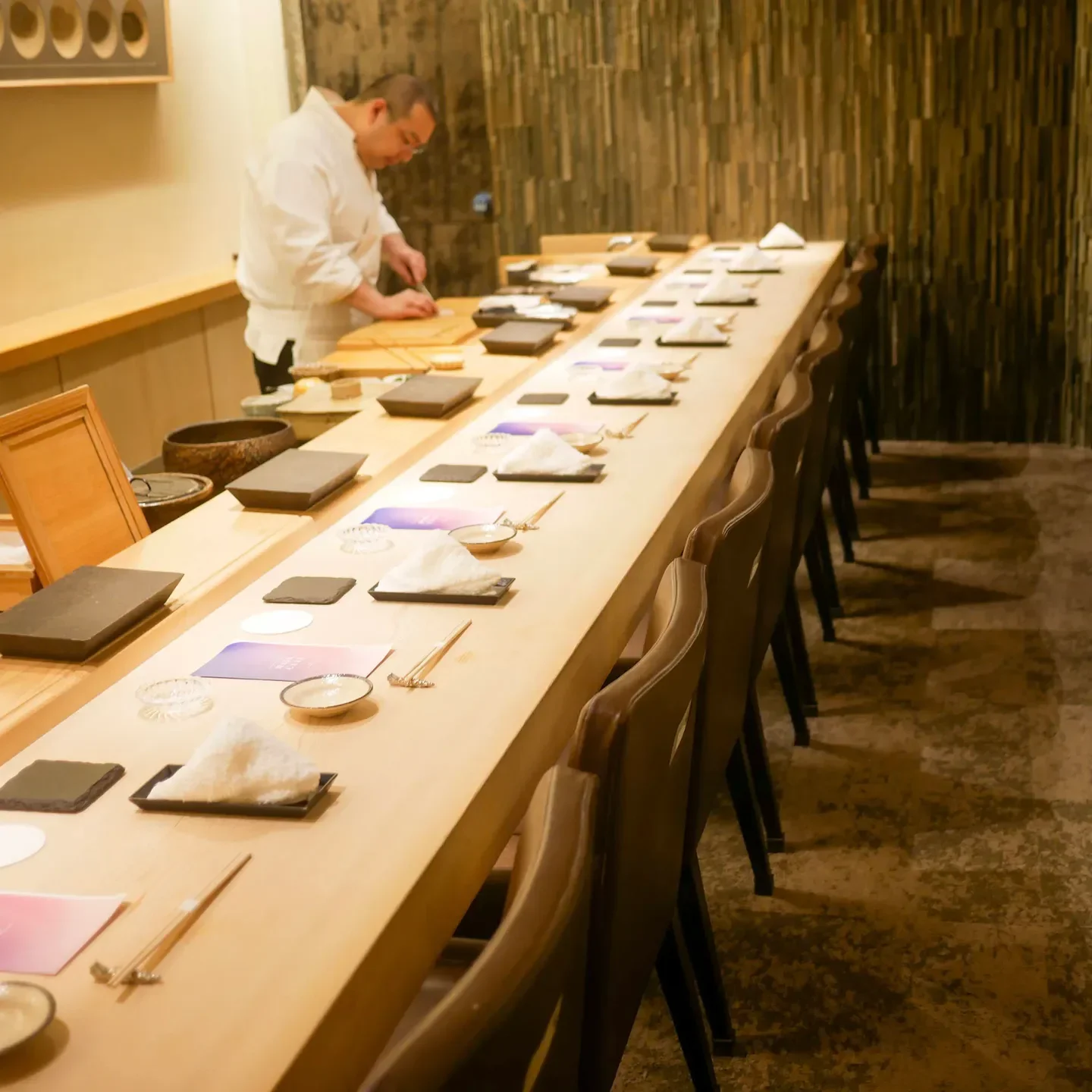 Interior of Sushi Namba in Tokyo, showcasing a chef preparing food at the counter.