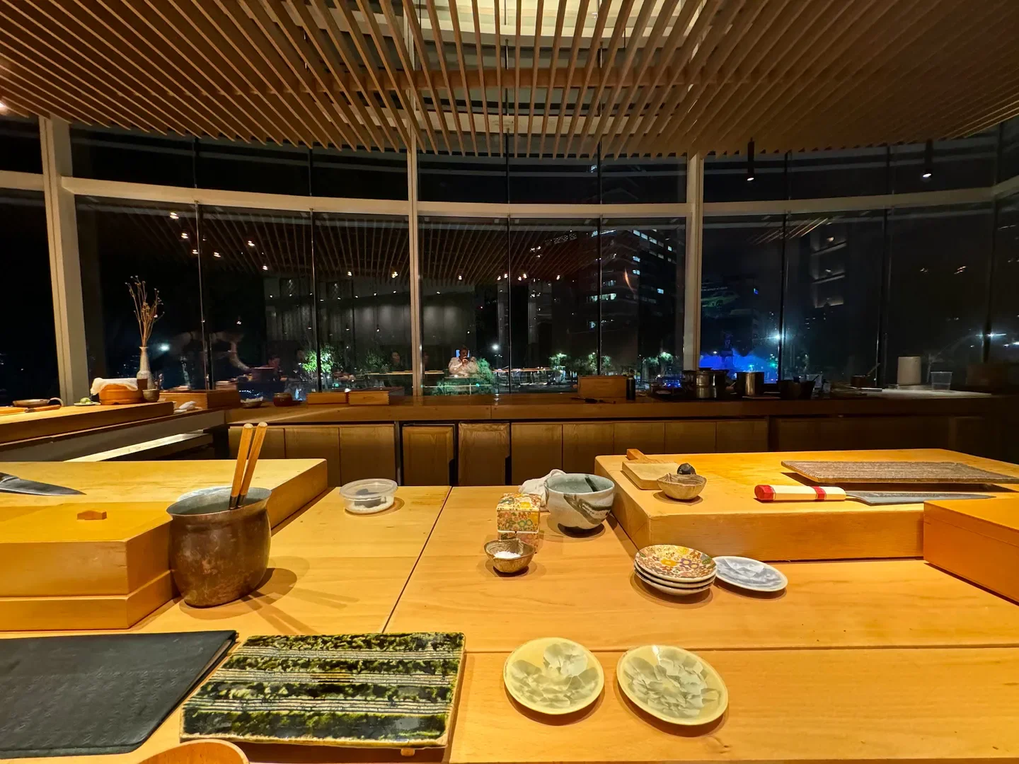 Interior of Sushi Tatsugoro in Mexico City with sushi bar and city views at night.