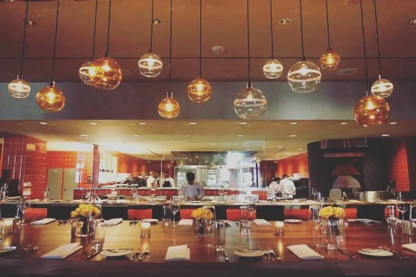 Interior of Sustenio in San Antonio, featuring hanging lights and a view into the kitchen.