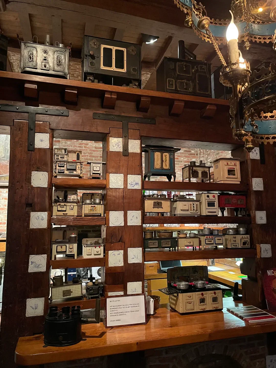 Interior of 't Fornuis restaurant in Antwerp, featuring a collection of antique stoves.