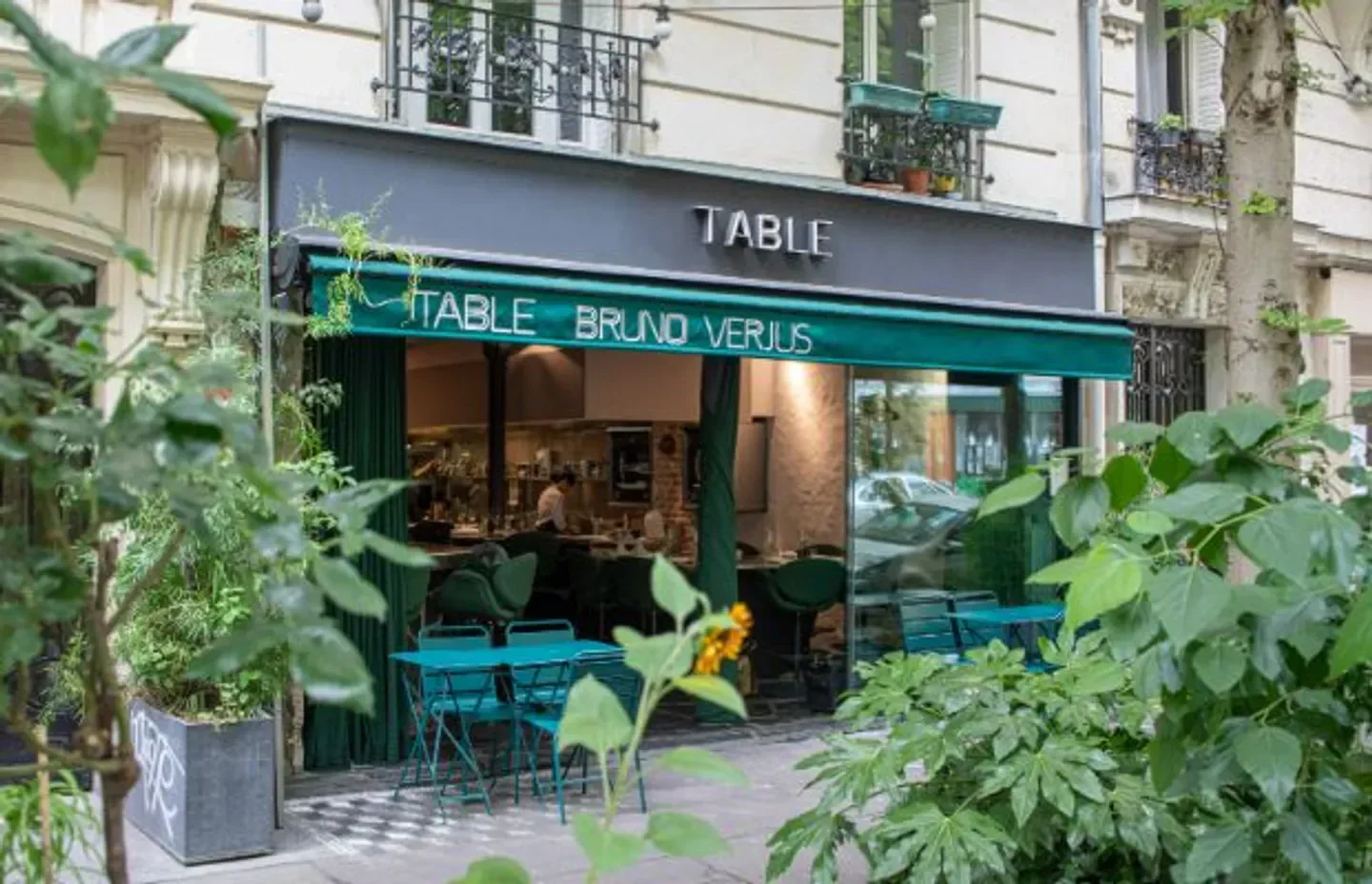 Exterior of Table by Bruno Verjus in Paris with outdoor seating and lush greenery.