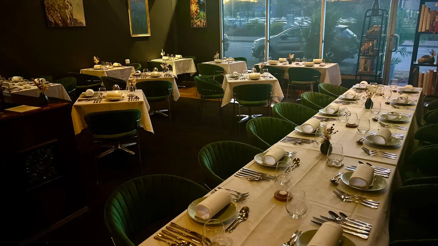 Elegant interior dining at Table by Canberra Gourmet, Canberra, with set tables and green chairs.