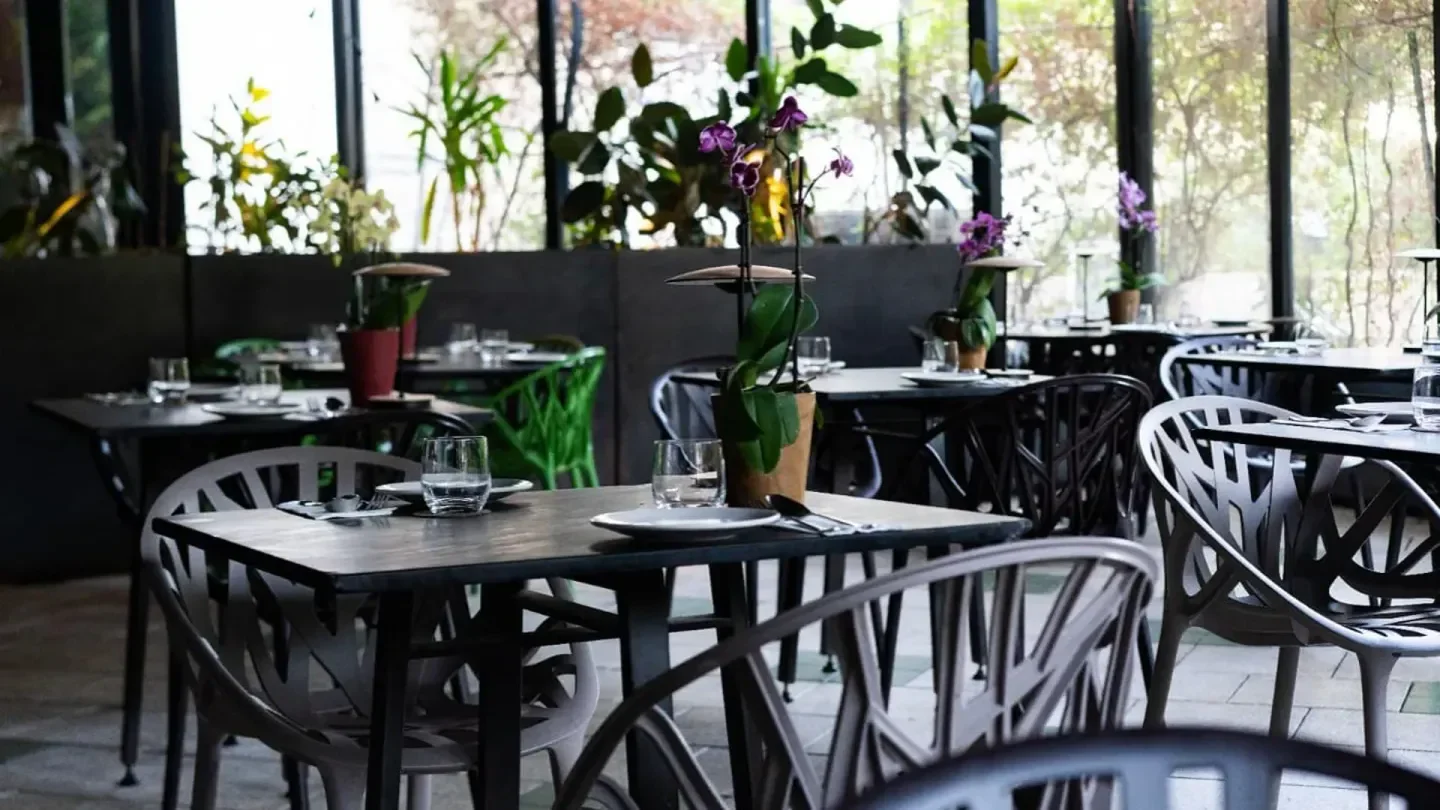 Interior of Taizu restaurant in Tel Aviv, featuring stylish tables and chairs, orchids.