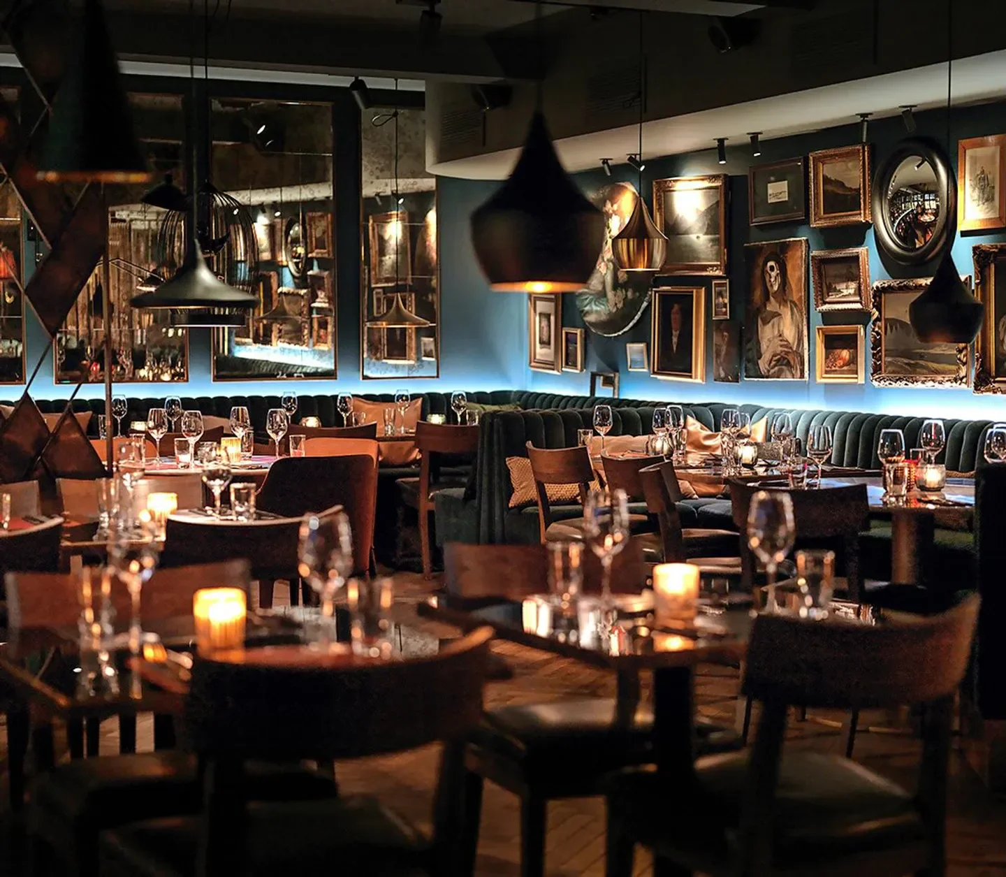 Cozy dining area at Teatro restaurant in Oslo, featuring artwork and intimate lighting.