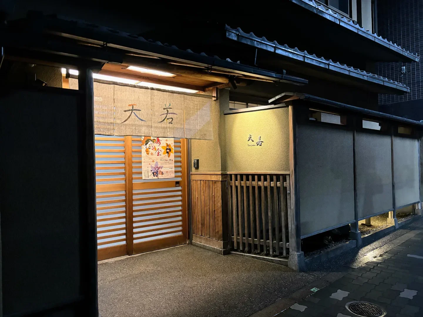 Entrance of Tenjaku restaurant in Kyoto at night with traditional Japanese architecture.