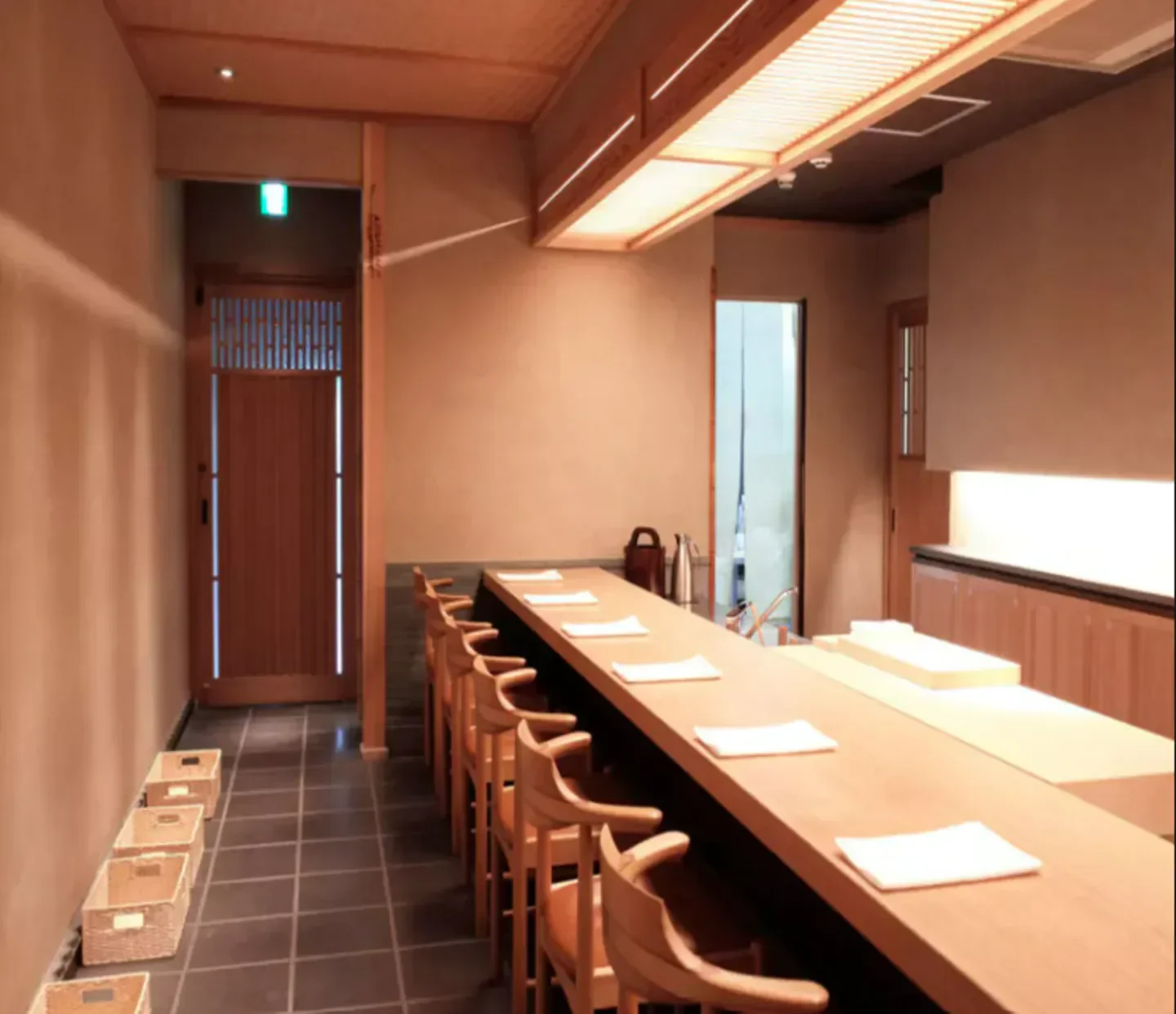 Interior of Tenjimbashi Aoki restaurant in Osaka, with wooden sushi bar and seating.