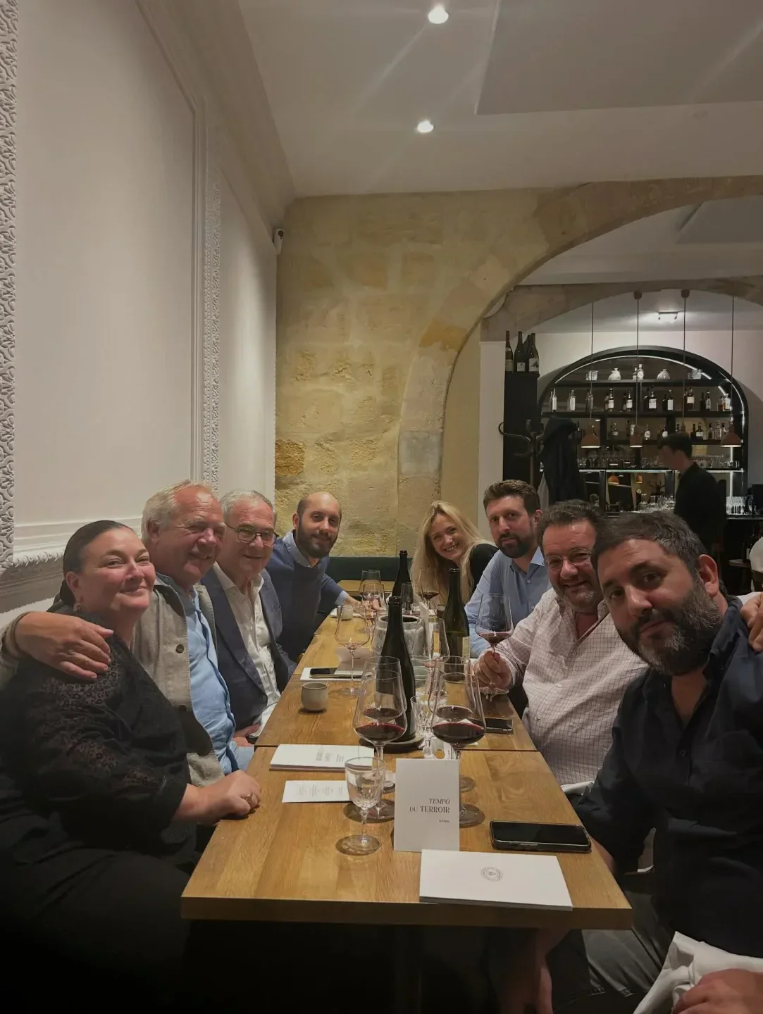 Group enjoying a meal at Tentazioni restaurant in Bordeaux, with wine and smiles.
