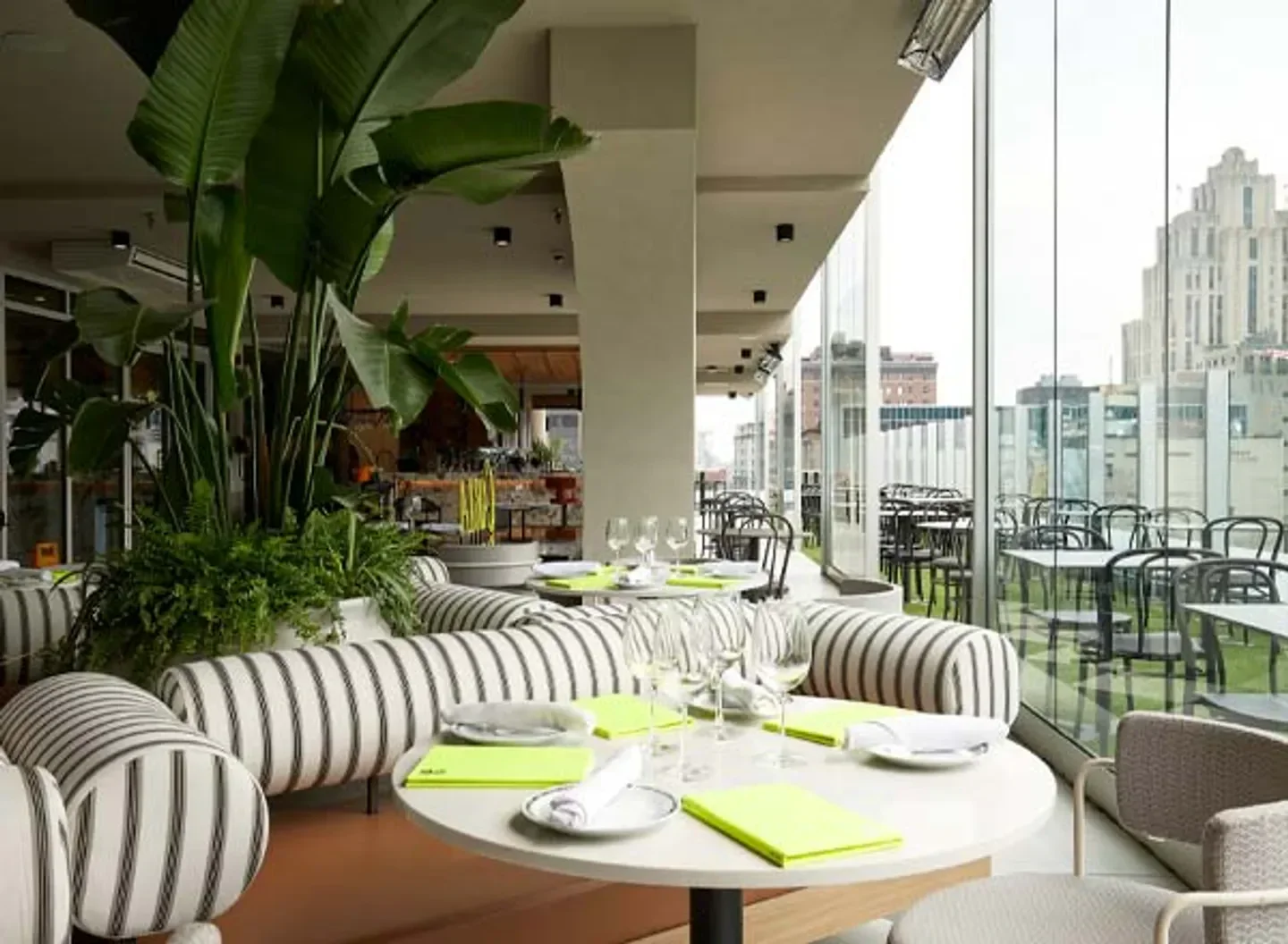Stylish interior of Terrasse Carla restaurant in Montreal, with modern furniture and city views.