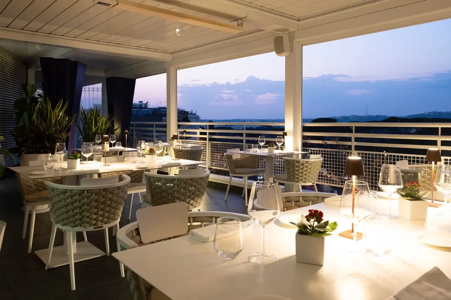 Elegant dining at Terrazza Borghese in Rome, featuring sunset views and stylish decor.