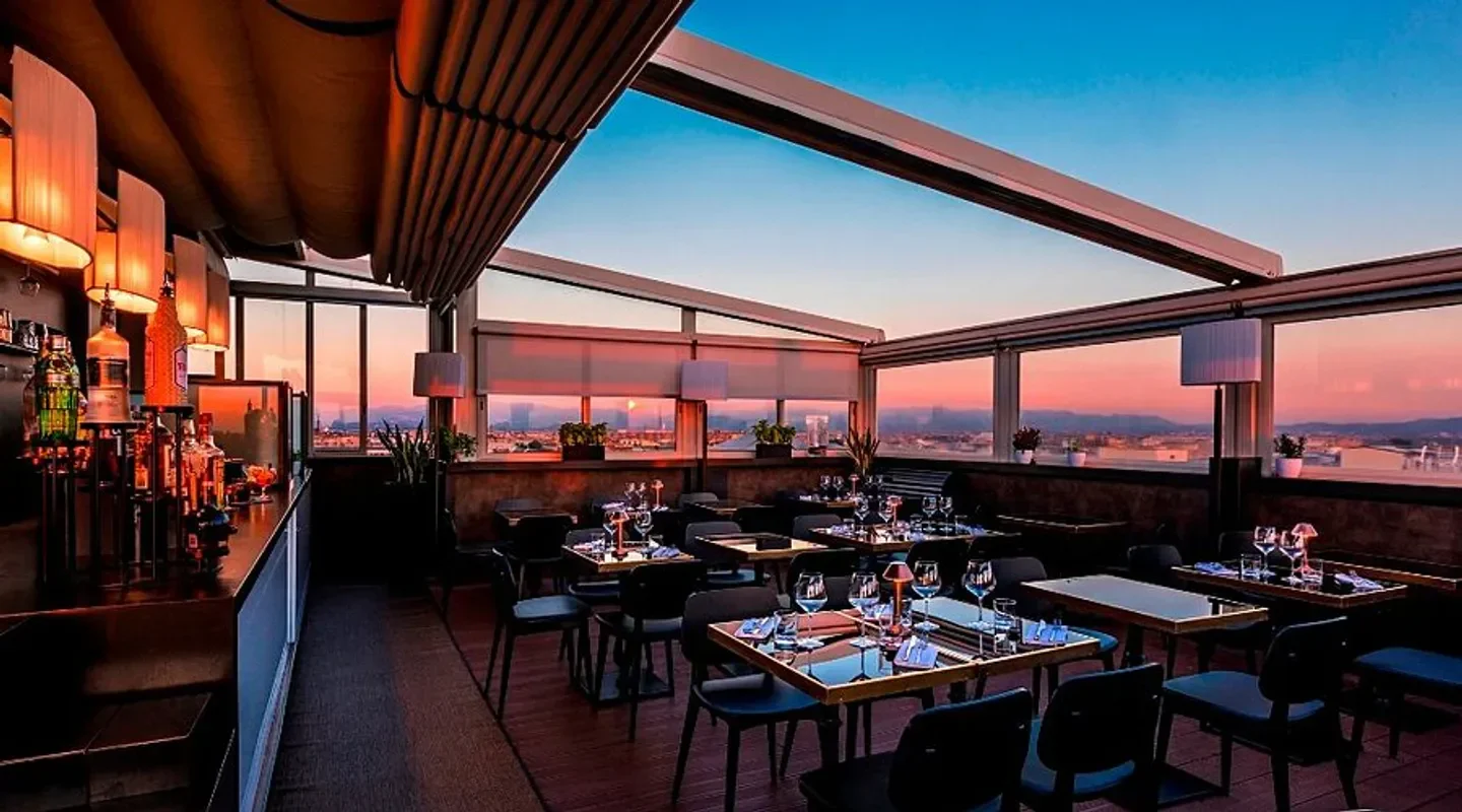 Rooftop dining at Terrazza Cielo in Rome during sunset with city views and bar.