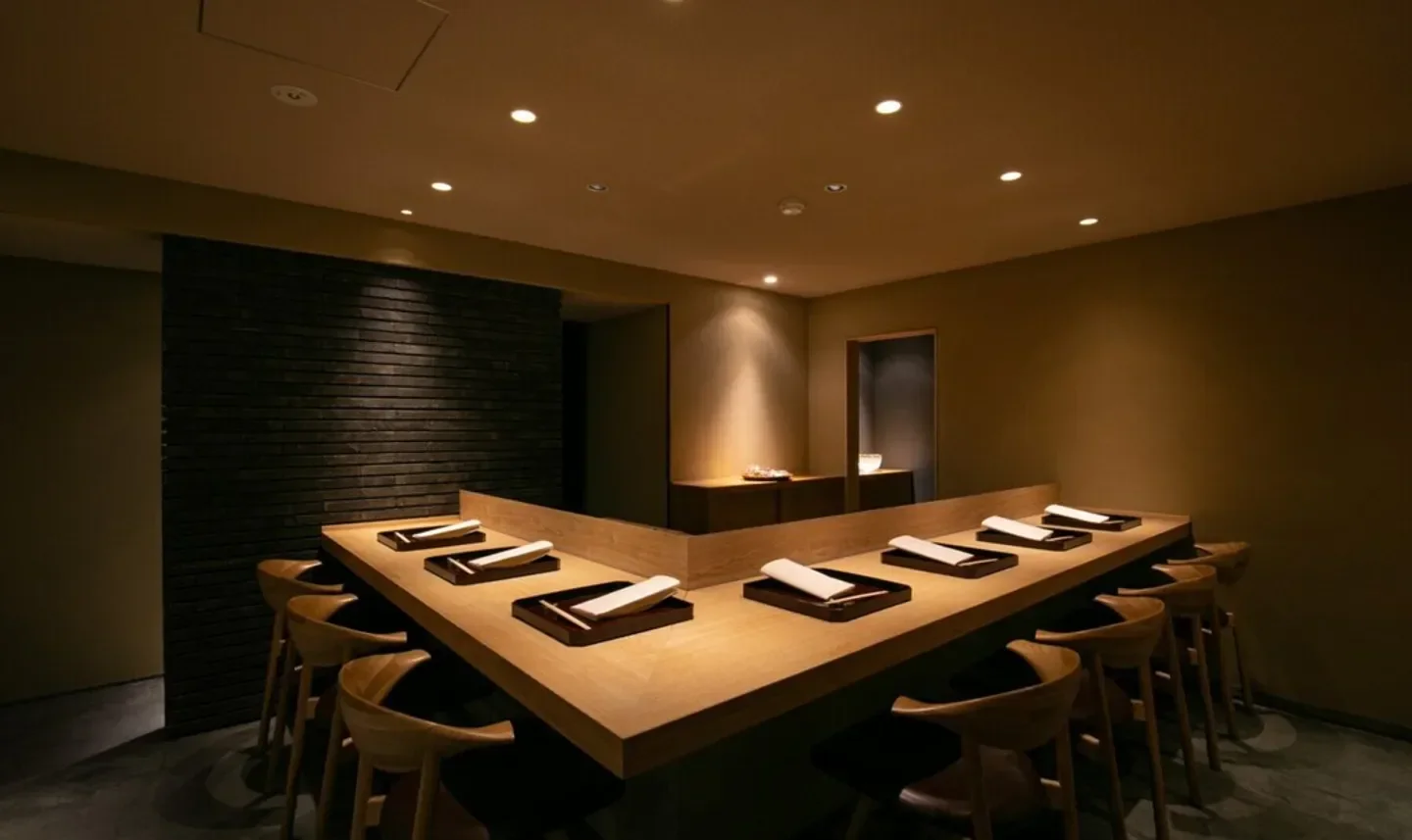 Interior of Teruya restaurant in Osaka. Featuring stylish wooden counter and dining chairs.