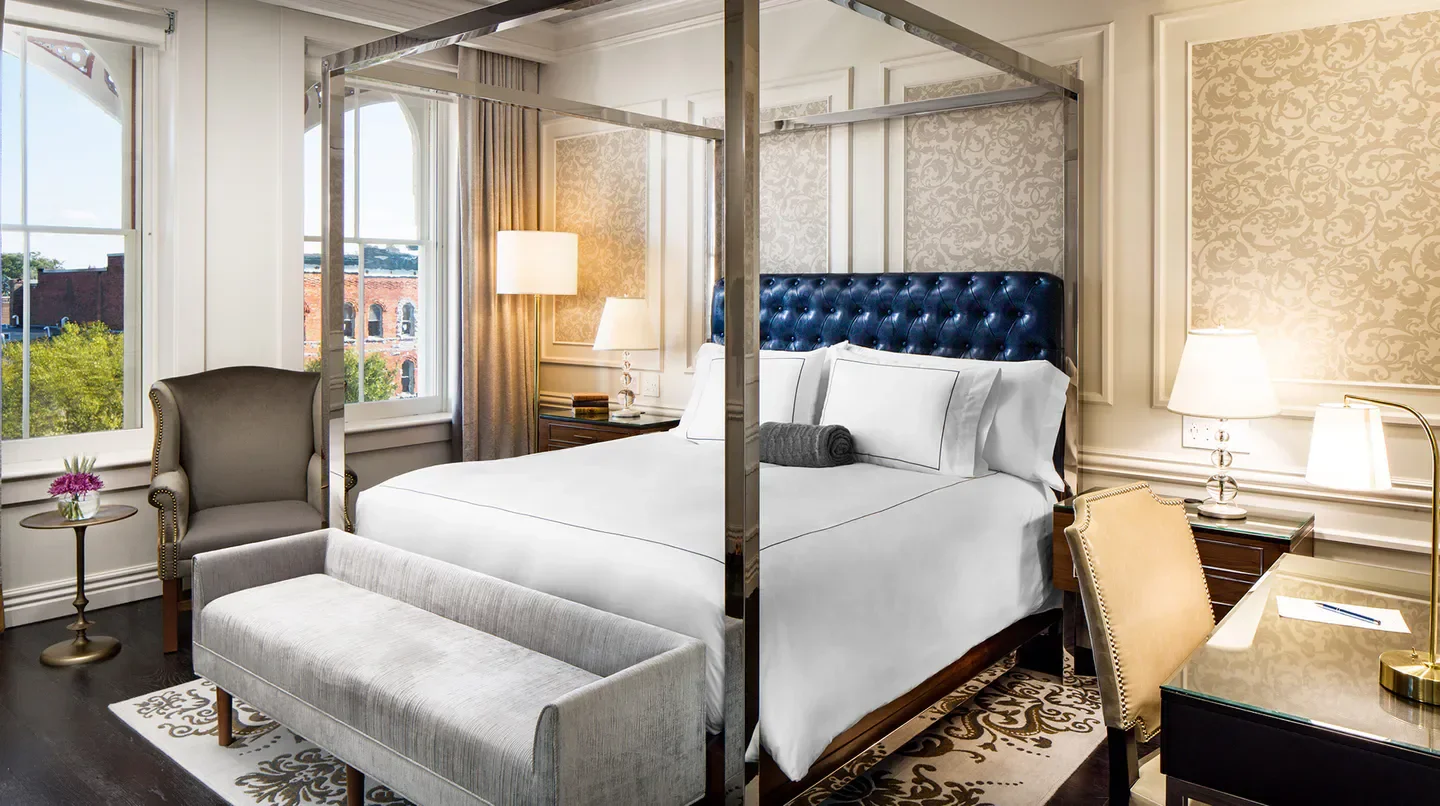 Elegant hotel room at The Adelphi Hotel in Saratoga, featuring a four-poster bed.